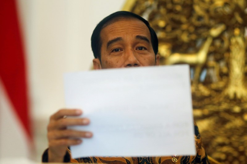 © Reuters. Indonesia's President Joko Widodo holds a paper during an interview with Reuters in Jakarta