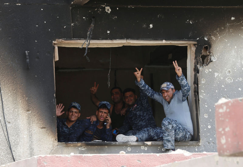 © Reuters. Members of Federal Police flash a victory sign during the fight with the Islamic States militants in the Old City of Mosul