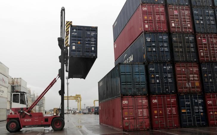 © Reuters. Workers load containers onto trucks from a cargo ship at a port in Jaragua do Sul, Santa Catarina state, Brazil