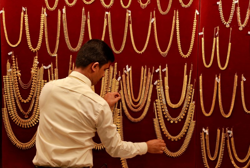 © Reuters. FILE PHOTO: Salesman arranges gold ornaments on display board inside a jewellery showroom during Akshaya Tritiya, a major gold buying festival, in Kochi