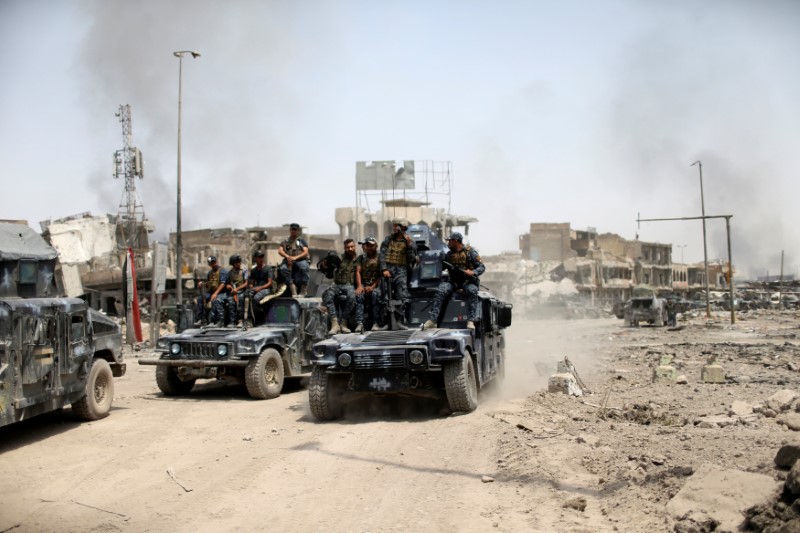 © Reuters. Iraqi Federal Police members ride in military vehicles during the fight with the Islamic State militants in the Old City of Mosul