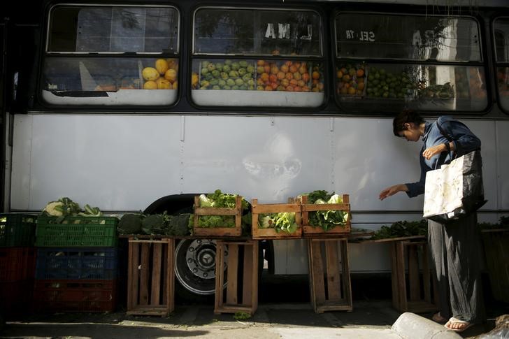 © Reuters. A woman looks for vegetables outside a bus called Sacolao in Santa Teresa neighborhood in Rio de Janeiro