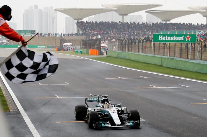 © Reuters. FILE PHOTO - Mercedes driver Lewis Hamilton of Britain gets the checkered flag to win the Chinese Formula One Grand Prix at the Shanghai International Circuit in Shanghai