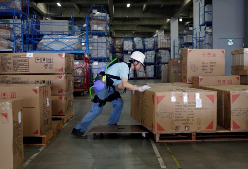 © Reuters. Okutani, 57, a contract worker of Ueda Co., Ltd., wears an Atoun Inc. Power Assist Suit, as he works at a distribution center in Kawasaki
