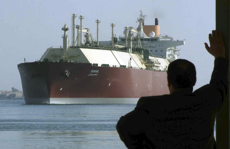 © Reuters. A man looks as the world's biggest Liquefied Natural Gas (LNG) tanker DUHAIL as she crosses through the Suez Canal