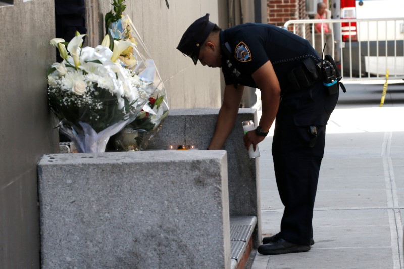 © Reuters. Policial acende uma vela, depois que um homem armado matou uma policial em Nova York, Estados Unidos