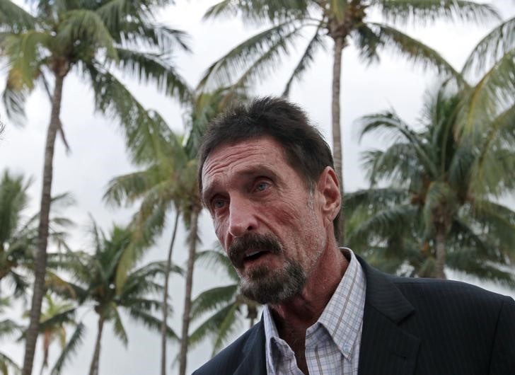 © Reuters. FILE PHOTO - Computer software pioneer McAfee speaks with reporters outside his hotel in Miami Beach