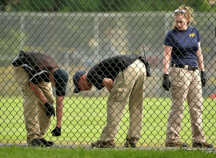 © Reuters. FBI technicians examine playing field at scene of shooting of Congressional baseball practice