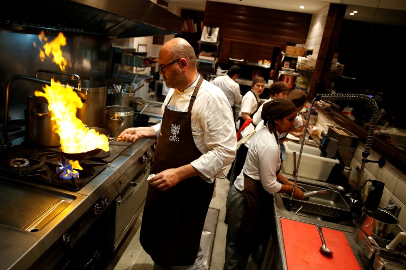 © Reuters. Chef Carlos Garcia cooks within the kitchen of the Alto restaurant in Caracas