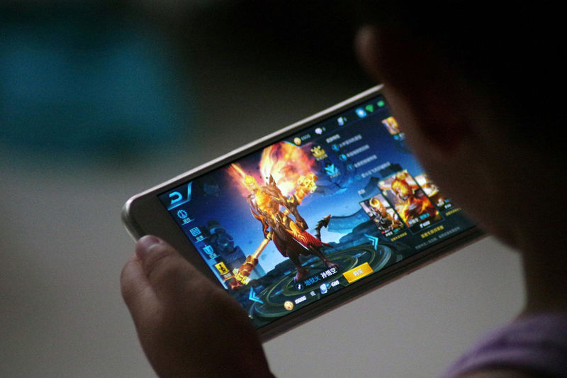 © Reuters. FILE PHOTO: A child is pictured as he plays the game "Honour of Kings" by Tencent at home in Dezhou