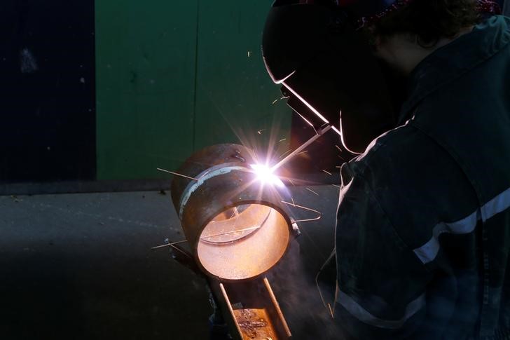 © Reuters. A city municipal worker welds a piece of metal as he works on a construction site in Paris