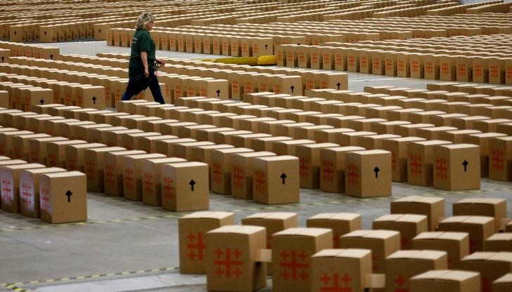 © Reuters. A worker walks between seat boxes during the final preparations for the German protestant church congress at the fairground in Berlin