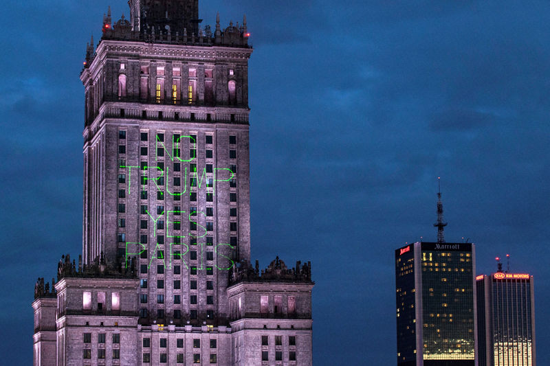 © Reuters. Greenpeace activist illuminate the Palace of Culture and Science with words "No Trump Yes Paris" in Warsaw.