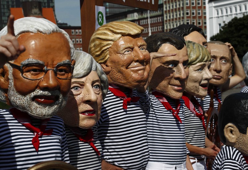 © Reuters. Manifestantes usam máscaras de alguns líderes mundiais em protesto em Hamburgo, durante cúpula do G20 na Alemanha