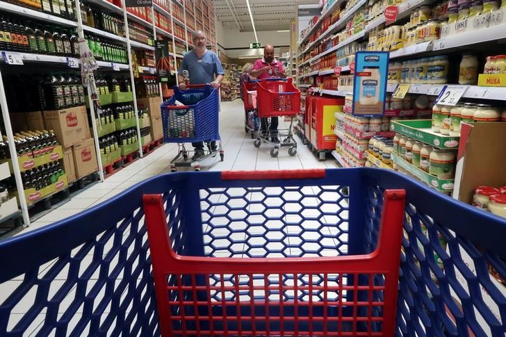 © Reuters. People push a shopping cart in a Carrefour supermarket in Cabrera de Mar