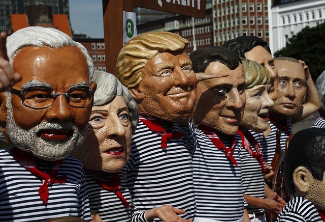 © Reuters. Activists from OXFAM wear masks depicting some of the world leaders during a demonstration at the harbor in Hamburg during the G20 summit