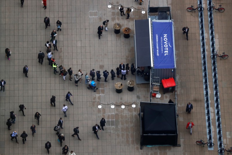 © Reuters. People queue for coffee at a plaza in the Canary Wharf financial district in London