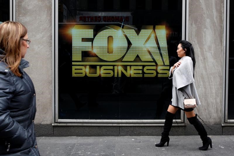 © Reuters. FILE PHOTO: People walk by the Fox business studios in the News Corporation headquarters in Manhattan, New York
