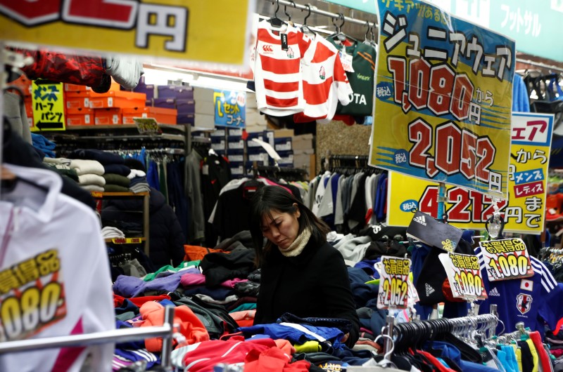 © Reuters. A woman chooses clothes at a shop in Tokyo