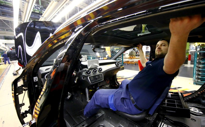 © Reuters. FILE PHOTO: An employee of German car manufacturer Mercedes Benz works on the interior of a GLA model at their production line at the factory in Rastatt