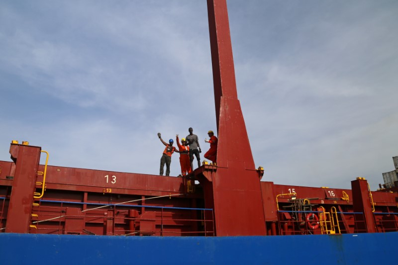 © Reuters. Workers in GambiaÕs main port of Banjul cheer from the top of a vessel