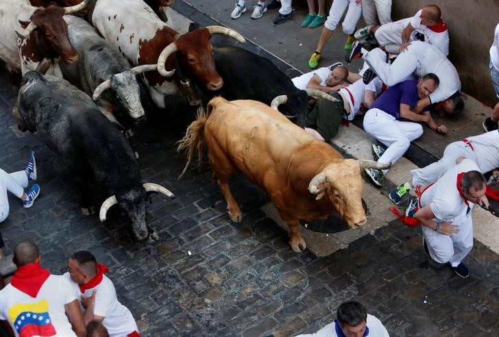 © Reuters. Homens caem durante o evento inaugural do festival de corridas de touros de Pamplona, na Espanha