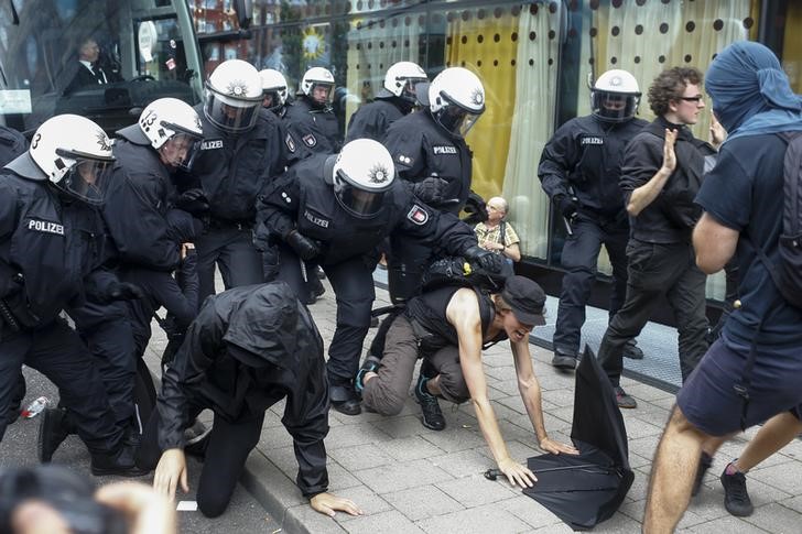© Reuters. Police officers push away activists who tried to block a street during the G20 summit in Hamburg
