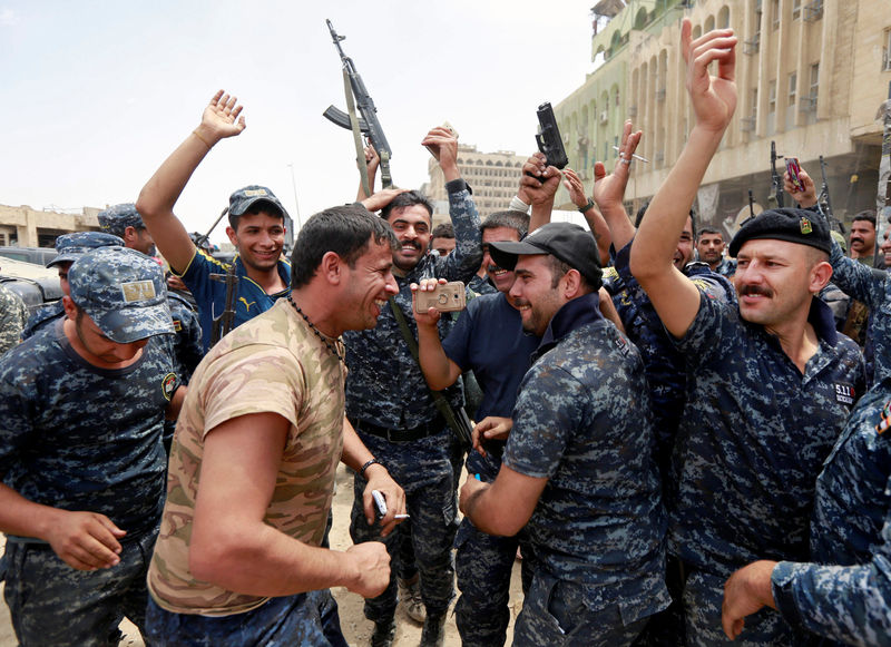 © Reuters. Iraqi Federal police celebrate in the Old City of Mosul