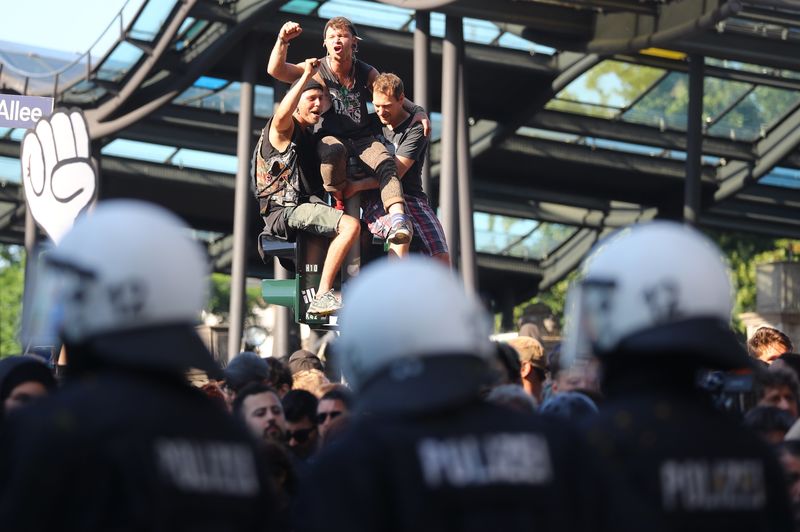 © Reuters. Protesters shout at the front of the German riot police during demonstrations at the G20 summit in Hamburg