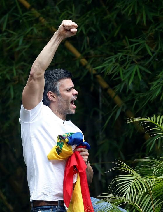 © Reuters. El líder opositor venezolano Leopoldo López, al que le concedieron arresto domiciliario después de más de tres años en la cárcel, saluda a sus seguidores en Caracas.