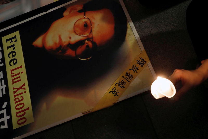 © Reuters. FILE PHOTO: A protester holds a candle next to a portrait of Chinese Nobel rights activist Liu Xiaobo demanding his release, during Chinese President Xi Jinping visiting, ahead of 20th anniversary of the city's handover from British to Chinese rule, 