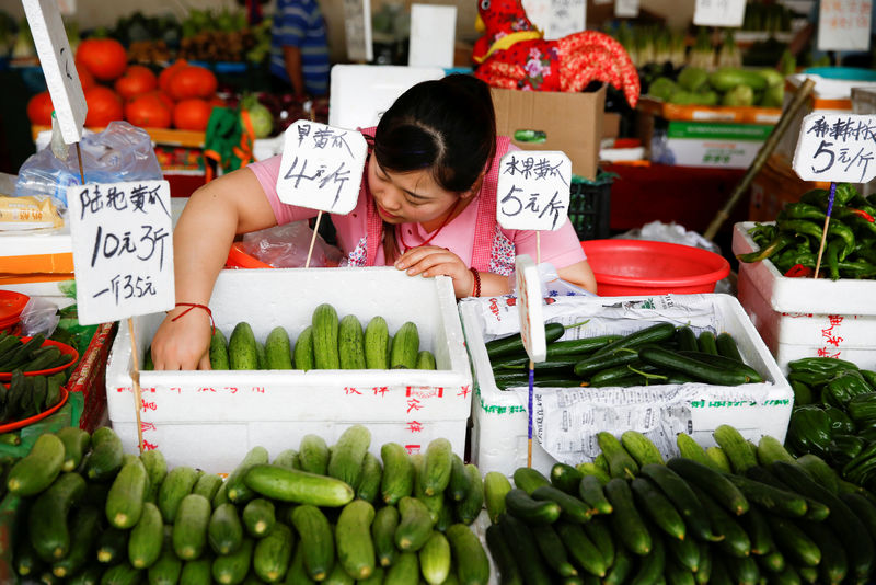 © Reuters. FILE PHOTO: A vendor arranges cucumbers at a fresh food market in Beijing