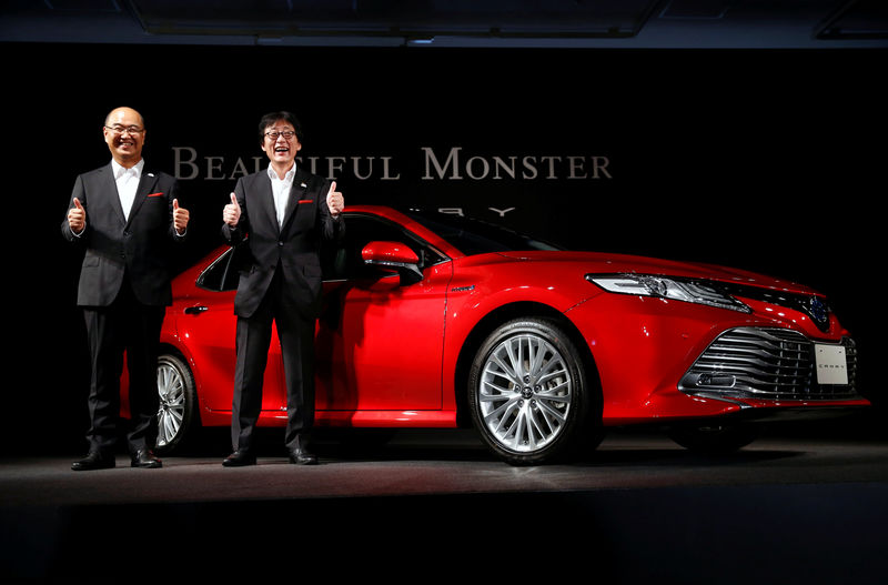 © Reuters. Moritaka Yoshida, president of Toyota's mid-size vehicle company, and Masato Katsumata, chief engineer of Toyota's Camry, pose with Toyota Camry sedan at a news conference for the car's unveiling in Japan, in Tokyo