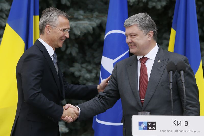 © Reuters. NATO Secretary General Stoltenberg and Ukrainian President Poroshenko shake hands during a joint news conference following a meeting of the NATO-Ukraine Commission in Kiev