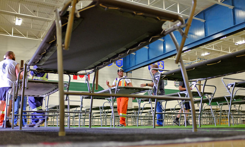 © Reuters. City public works employees Jake LeBrun and Jordan Wiseman set up cots for wildfire evacuees in Prince George