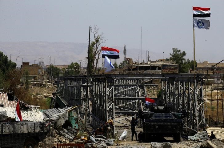 © Reuters. A military vehicle of Iraqi security forces is seen next to an old bridge destroyed by clashes in the Old City of Mosul