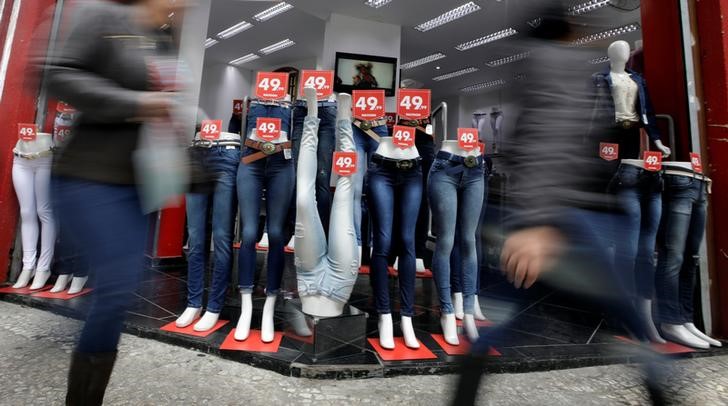 © Reuters. Pessoas passam em frente a loja em São Paulo