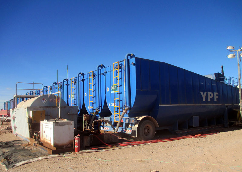 © Reuters. Trucks unload water to be used in the shale oil and gas extraction fracking process in the Loma Campana Vaca Muerta shale oil and gas drilling site