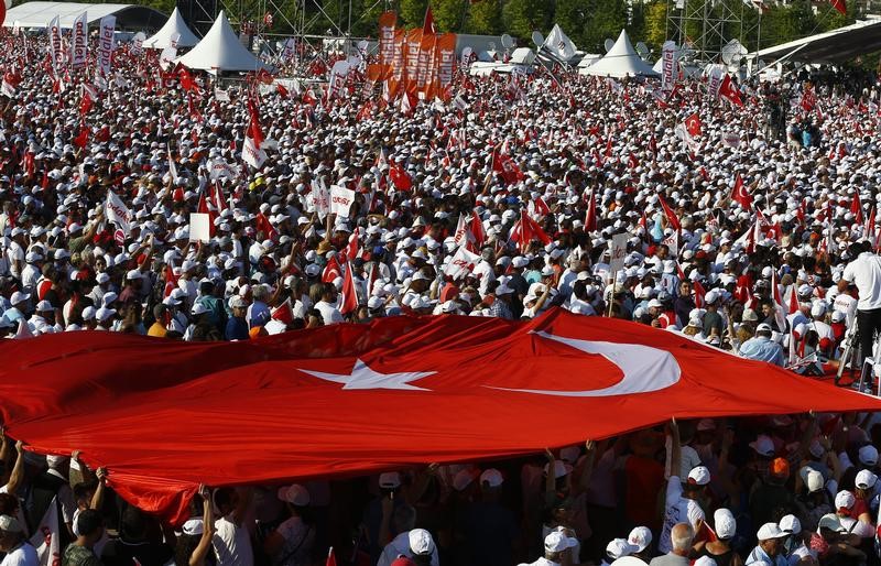 © Reuters. FILE PHOTO: People carry a huge Turkish flag during a rally to mark the end of the main opposition CHP leader Kilicdaroglu's 25-day long protest, dubbed "Justice March", against the detention of the party's lawmaker Berberoglu, in Istanbul