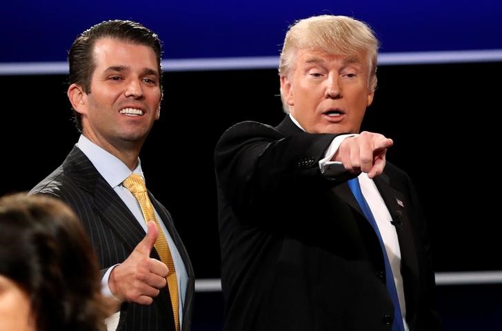 © Reuters. Donald Trump Jr. gives a thumbs up beside his father Donald Trump after presidential debate in Hempstead, New York