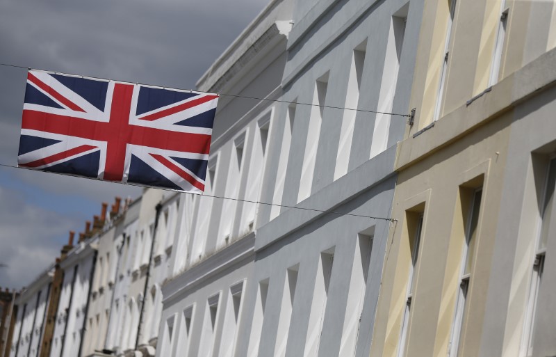 © Reuters. A Union flag hangs across a street of houses in London