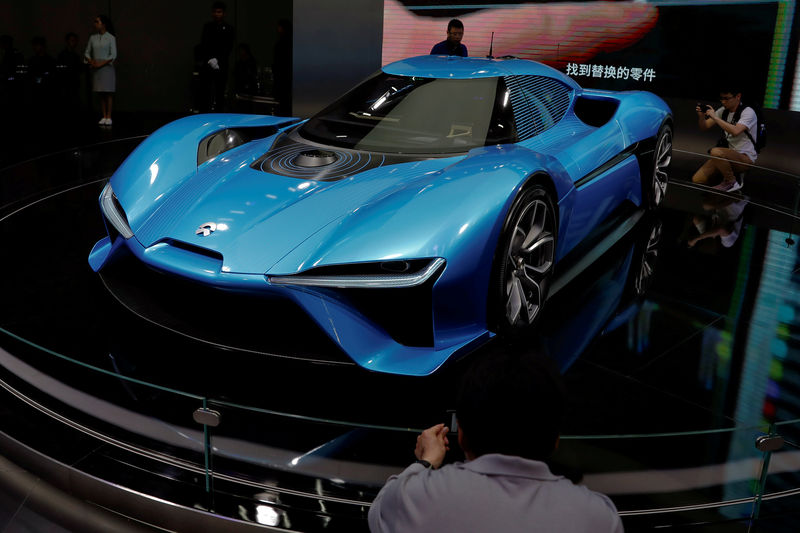 © Reuters. FILE PHOTO: People gather around Nio EP9 electric car displayed at the auto show in Shanghai