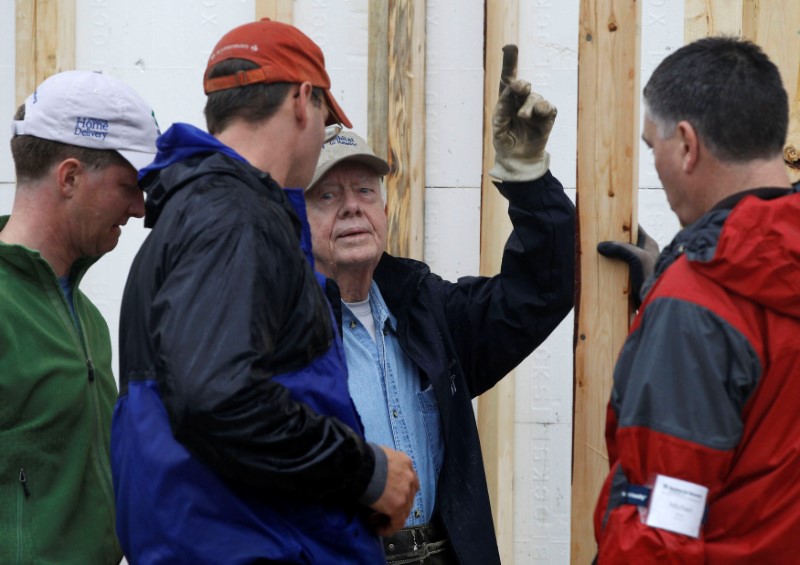 © Reuters. FILE PHOTO --  Former U.S. President Jimmy Carter attends Habitat for Humanity home building site in Washington