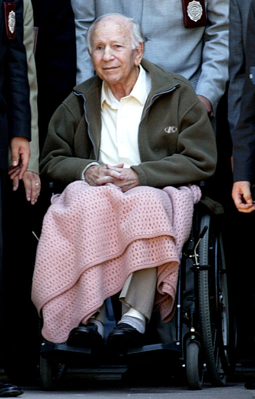 © Reuters. FILE PHOTO: Former leader of the Colonia Dignidad (dignity community), Paul Schaefer (C), sits in a wheelchair outside Interpol police station after questioning in Santiago