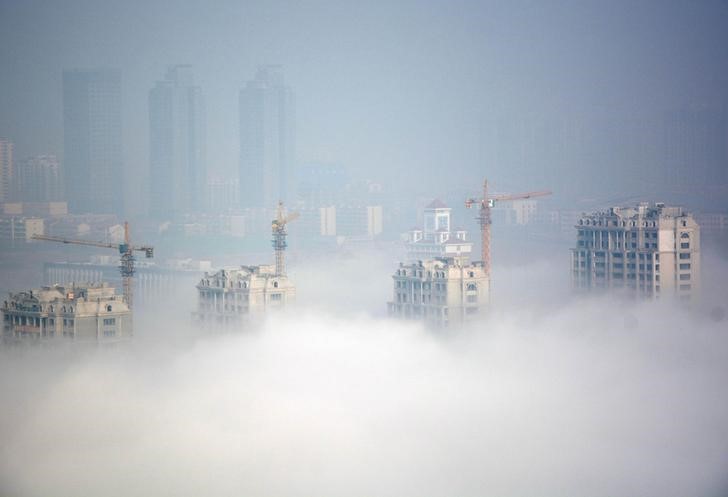 © Reuters. Buildings under construction are seen during a hazy day in Rizhao