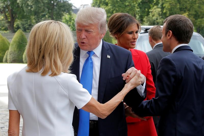 © Reuters. French President Emmanuel Macron greets US First Lady Melania Trump while his wife Brigitte Macron welcomes US President Donald Trump at Les Invalides museum in Paris