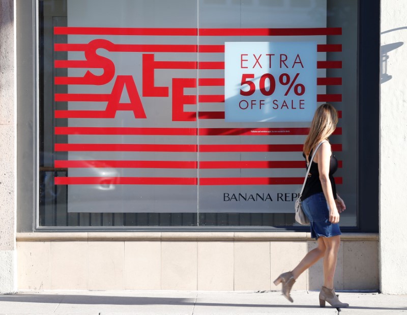 © Reuters. A woman walks past a sign advertising a sale in the Old Town shopping area of Pasadena