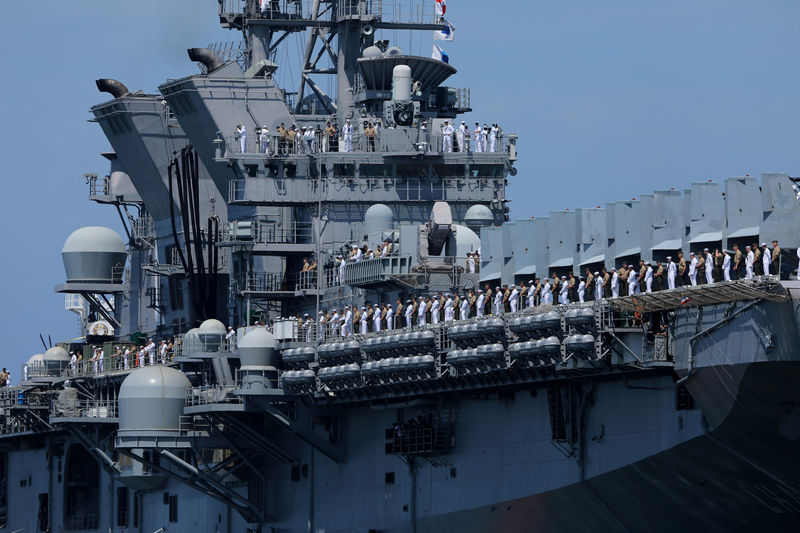 © Reuters. U.S. Marines and sailors man the rails aboard the USS America (LHA-6) as they leave port and deploy to the Pacific with the America Amphibious Ready Group from Naval Base San Diego