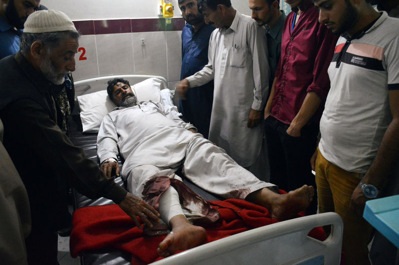 © Reuters. Well wishers stand by the bed of a civilian injured during cross border firing at the Neelum District Hospital in Athmuqam