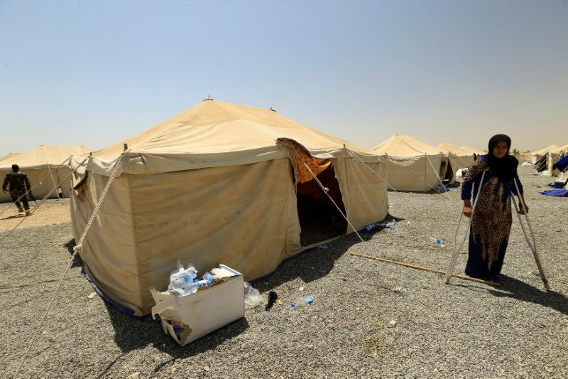 © Reuters. A woman on crutches who is a relative of men accused of being Islamic State militants is seen at a camp in Bartella